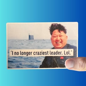 May include: A photo of a man with dark hair smiling in front of a body of water. The man is wearing a dark jacket. The text 'I no longer craziest leader. Lol.' is printed on the image.
