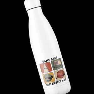 May include: White insulated water bottle with a black cap and a graphic that reads "SAME SHIT DIFFERENT HAT." The graphic features four images of different hats, including a KKK hood, a Confederate flag hat, a military hat, and a red baseball cap.