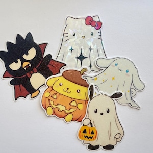 May include: A collection of five cartoon stickers featuring Halloween-themed characters. Includes a black bat, a white ghost, a pumpkin-shaped character, a white ghost with stars, and a Hello Kitty ghost with a red bow.