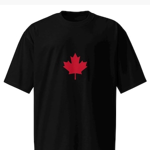 May include: Black t-shirt featuring a red maple leaf emblem. The short-sleeved shirt has a crew neck and a simple, classic design. The maple leaf is centered on the chest.