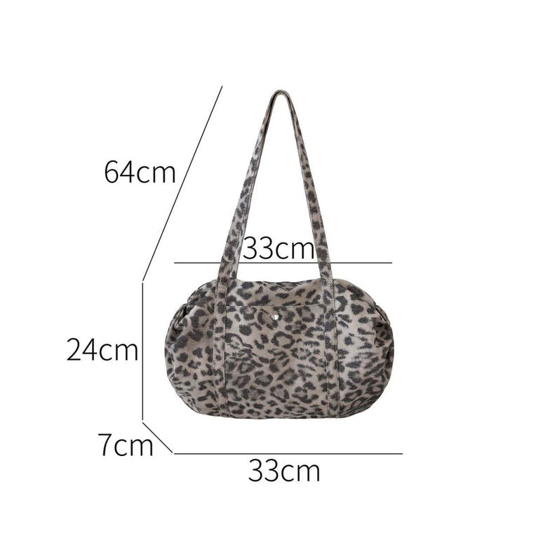 Puede incluir: Un bolso tote con estampado de leopardo de forma redondeada. El bolso mide 33 cm de largo, 24 cm de alto y 7 cm de ancho. Las asas se extienden 64 cm desde la parte superior del bolso. El bolso tiene una paleta de colores neutros de negro, gris y beige.