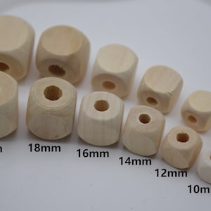 以下が含まれることがあります： 未完成の木製立方体ビーズのコレクション。サイズは10mmから20mmまで。各ビーズには、紐を通すための中心穴があります。サイズはミリメートルで表示されています。