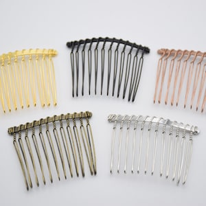 May include: Five hair combs in different colors: gold, black, rose gold, bronze, and silver. Each comb has a curved shape and a twisted wire design.