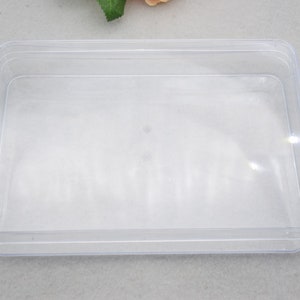 Op de afbeelding: Een rechthoekige opbergdoos van transparant plastic met een glad oppervlak.