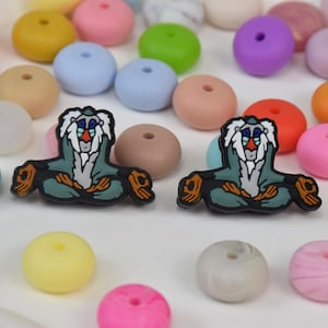 Puede incluir: Surtido colorido de cuentas redondas en varios colores, incluyendo naranja, rosa, verde y azul. También hay dos amuletos de mono de dibujos animados. Adecuado para la fabricación de joyas y proyectos de artesanía.
