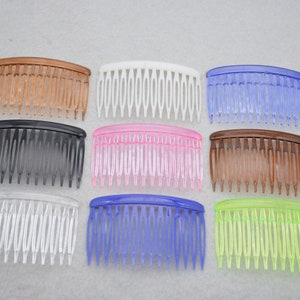 May include: Assortment of ten plastic hair combs in various colours, including brown, black, white, pink, blue, and green. The combs are all the same size and shape, with a curved handle and a row of teeth.