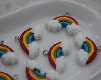 May include: Five rainbow-colored charms with white clouds, each with a silver loop for attaching to a necklace or bracelet. The charms are made of resin and have a glossy finish.