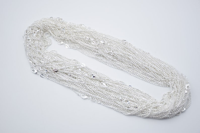May include: A pile of silver chain, a popular material for jewelry making.