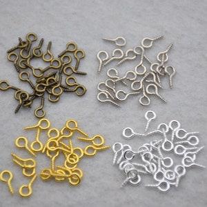 May include: Assortment of screw-back eye pins in gold, bronze, and silver finishes. These eye pins are ideal for jewelry making and crafting.