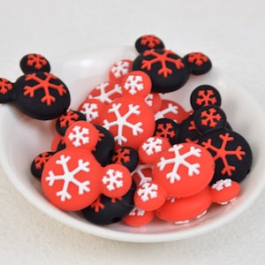 Könnte beinhalten: Eine Schüssel mit roten und schwarzen Silikonperlen mit Schneeflocken- und Mickey-Mouse-Motiven.