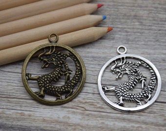 May include: Two silver and bronze dragon charms with a circular design. The dragon is curled around itself with its head facing forward. The charms have a loop at the top for attaching to a necklace or bracelet.