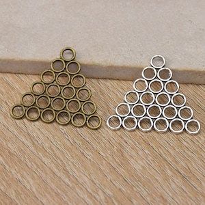 Pode incluir: Dois pingentes de metal em forma de triângulo, um em ouro antigo e outro em prata, cada um feito de uma série de anéis conectados.