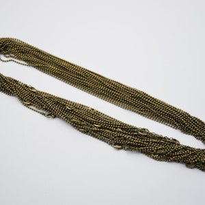 May include: A bulk pack of 100 bronze ball chain necklaces. Each chain is approximately 20 inches long and features a classic ball chain design.