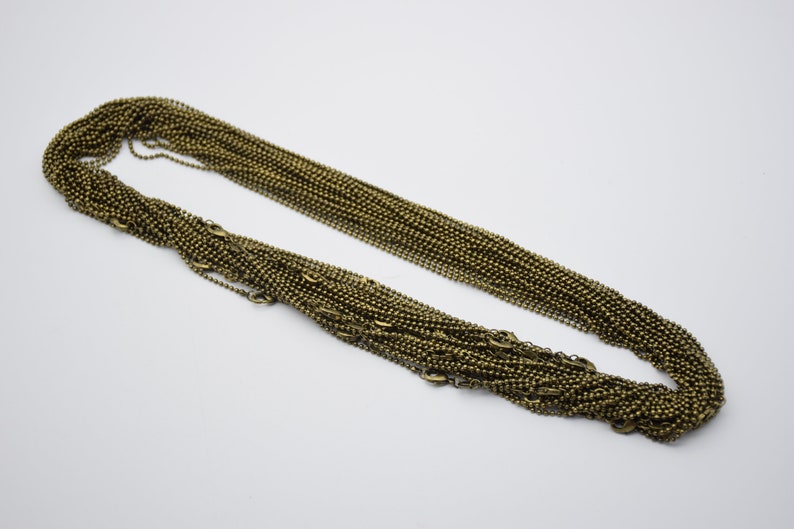 May include: A bulk pack of 100 bronze ball chain necklaces. Each chain is approximately 20 inches long and features a classic ball chain design.