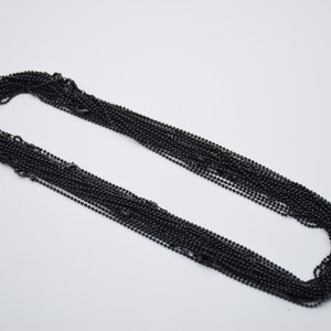May include: A bulk pack of black ball chain, a type of chain commonly used for necklaces, keychains, and other jewelry.