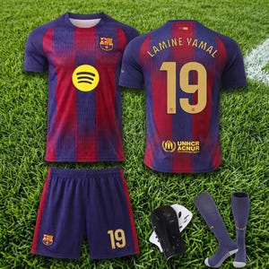 May include: A football kit featuring a blue and red striped jersey with the Spotify logo and FC Barcelona crest, a jersey back with the name LAMINE YAMAL and number 19, blue shorts with the number 19, shin guards, and a pair of blue football socks.
