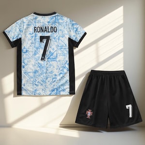 May include: A white and blue soccer jersey with black trim and the name "RONALDO" and the number "7" on the back. A black soccer short with a white "7" and the Portuguese crest on the side.