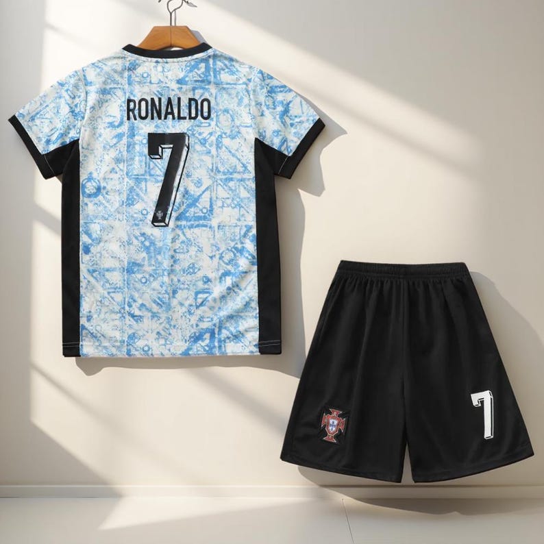 May include: A blue and white soccer jersey with black trim and the name "RONALDO" and the number "7" on the back. A black soccer short with the Portuguese national team crest and the number "7" on the back.