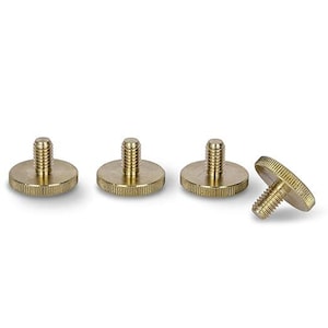 May include: Four gold-coloured metal screw-in feet with a flat base and a threaded top.