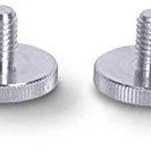 Peut inclure: Quatre adaptateurs de vis de trépied en métal argenté avec un dessus fileté et une base plate. Les adaptateurs sont conçus pour être fixés à un trépied ou à d'autres équipements photo.