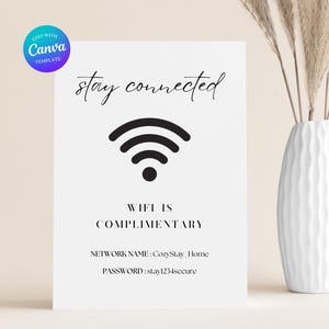 Puede incluir: Un letrero blanco con las palabras "stay connected" en escritura elegante sobre un símbolo Wi-Fi negro. Debajo, se lee "WIFI IS COMPLIMENTARY". También se enumeran el nombre de la red y la contraseña.