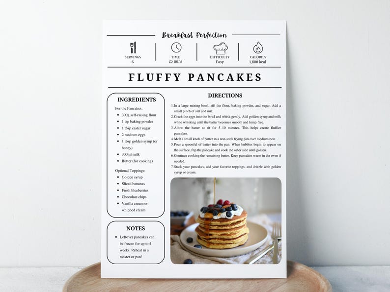 K&ouml;nnte beinhalten: Rezeptkarte f&uuml;r "Fluffy Pancakes" mit Zutaten und Anweisungen. Die Karte zeigt einen Stapel Pfannkuchen mit Blaubeeren und Sirup. Das Rezept ist f&uuml;r 4 Portionen und dauert 25 Minuten.