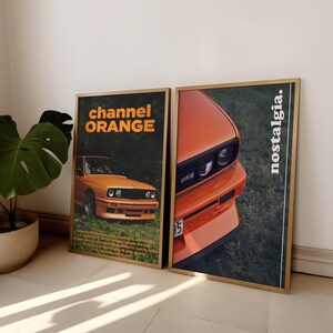 May include: Two framed posters with a vintage aesthetic featuring a close-up of an orange BMW M3 car. The poster on the left has the text "channel ORANGE" and the poster on the right has the text "nostalgia."