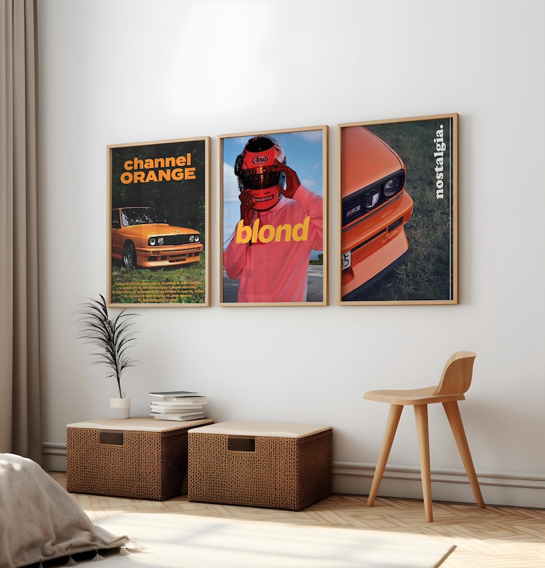 May include: Three framed posters featuring a car, a man wearing a helmet, and a car. The posters all share a similar style, with a white background and black text. The text on the posters reads "channel orange", "blond", and "nostalgia."