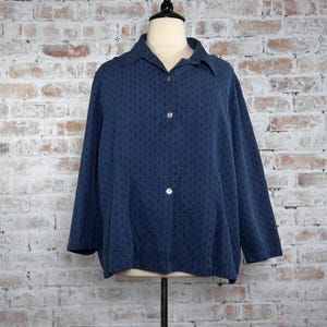 May include: A navy blue long-sleeved button-down shirt with a small white geometric pattern.
