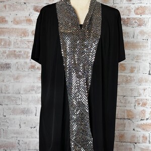 May include: A black top with a silver sequined panel down the front. The top has a V-neck and short sleeves.