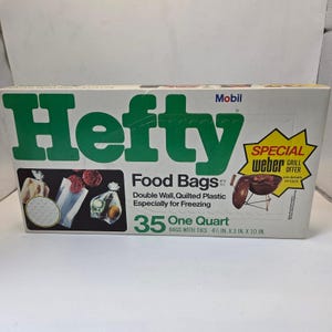 Puede incluir: Una caja de bolsas de alimentos Hefty, diseñadas para congelar. La caja es blanca con letras verdes y presenta imágenes de alimentos en bolsas. Contiene 35 bolsas de un cuarto de galón con lazos, que miden 11,4 cm x 7,6 cm x 25,4 cm.