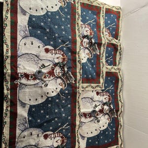 May include: Set of three woven kitchen towels featuring a winter scene with snowmen wearing hats and scarves. The towels have a blue background with white snowflakes and a red, green, and white border.