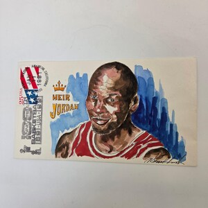 May include: Watercolor portrait of Michael Jordan on a rectangular card. The image features a red and white jersey, with the text "HEIR JORDAN" and a stamp with "25 USA" and "100 ANNIVERSARY BASKETBALL 1891-USA-1991".