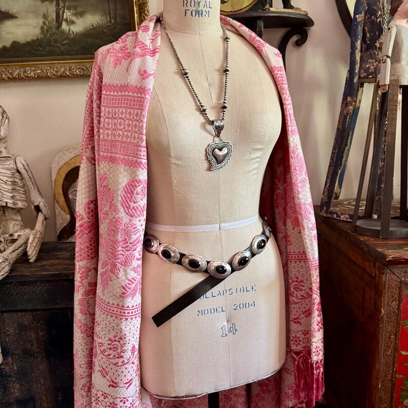 May include: A mannequin displays a pink and white patterned shawl, a silver heart pendant necklace, and a black leather belt with silver oval accents. The mannequin is a vintage Royal Form model.