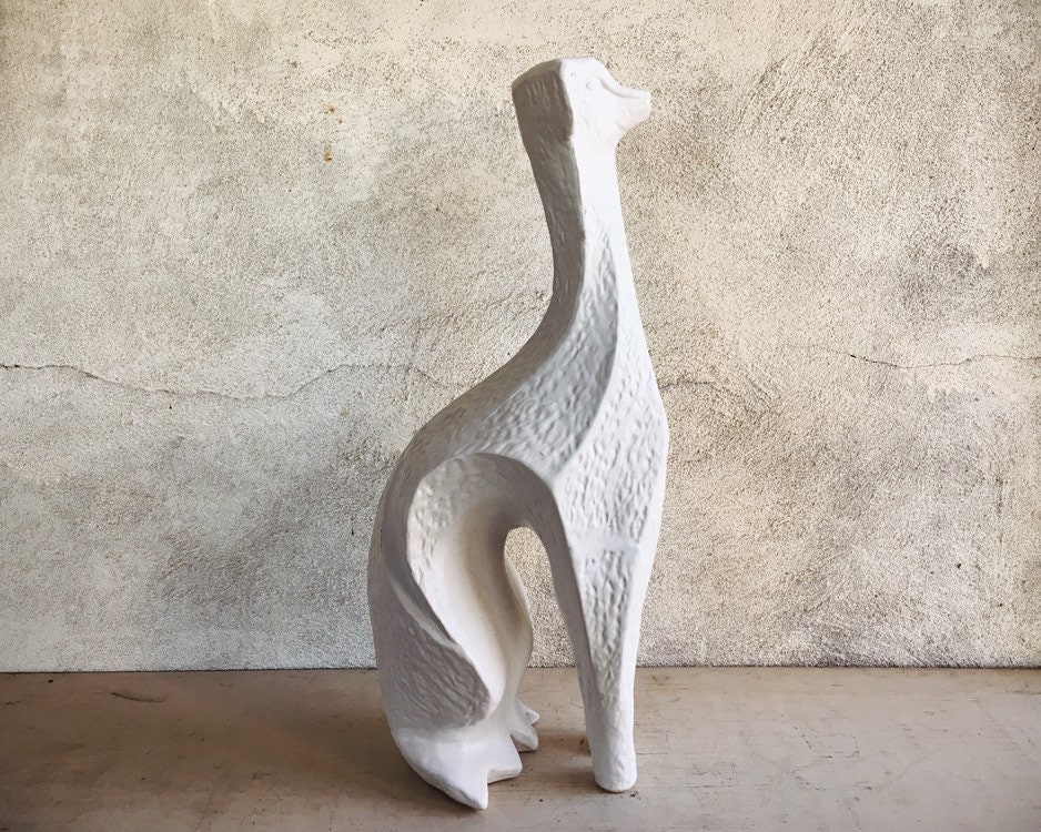 white ceramic greyhound statue