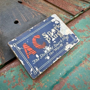 May include: A blue and white spark plug box with the text "AC Spark Plug The Standard Spark Plug of the World".