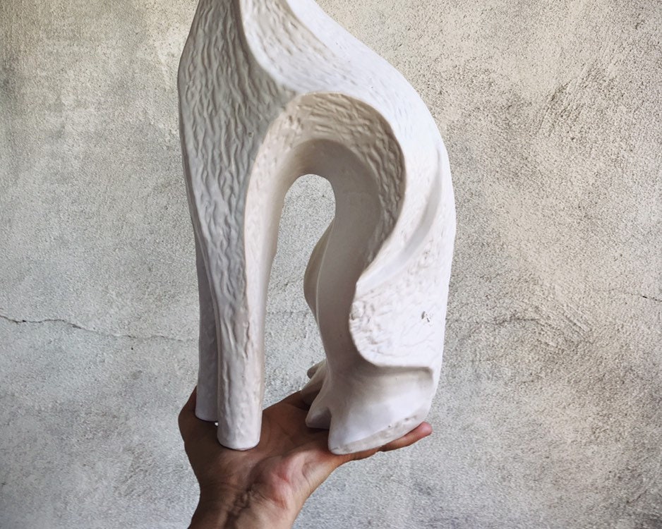 white ceramic greyhound statue