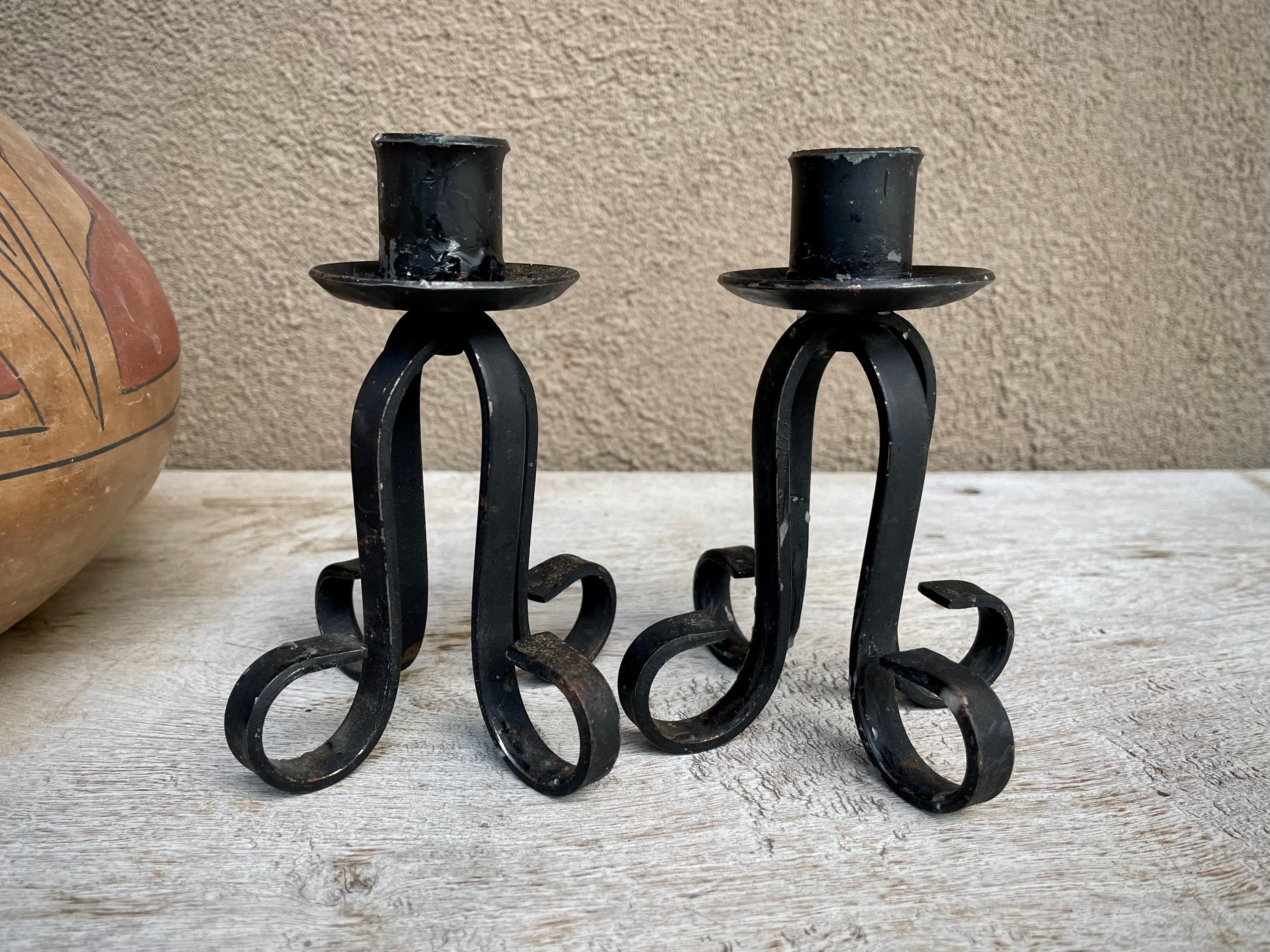 A pair of wrought iron Gothic candlesticks