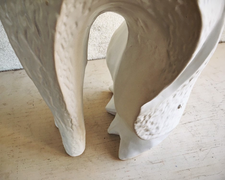white ceramic greyhound statue