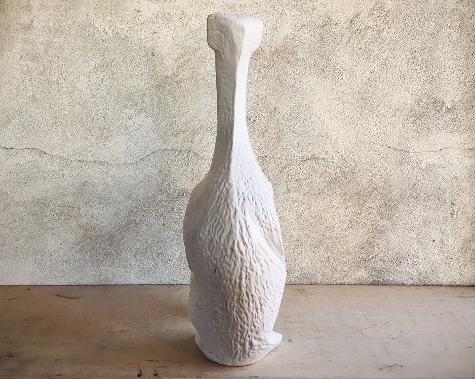 white ceramic greyhound statue