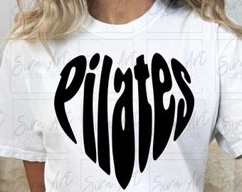 May include: White t-shirt with a black heart-shaped design that spells out "Pilates". The shirt is a casual style, suitable for fitness or everyday wear. The design is centered on the chest.