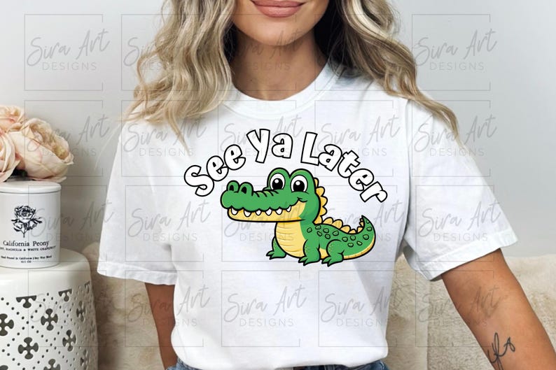 K&ouml;nnte beinhalten: Wei&szlig;es T-Shirt mit einem gr&uuml;nen Comic-Alligator und dem Text "See ya Later" in Schwarz.