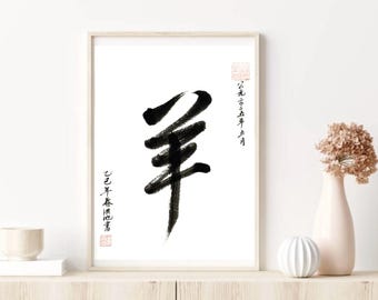May include: A framed artwork with a black ink calligraphy symbol on a white background. The symbol is a vertical stroke with three horizontal strokes above it. Chinese characters and red stamps are also present. The artwork is displayed on a light wooden surface.