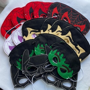 Peut inclure: Un ensemble de masques de super-héros en feutre pour enfants. Les masques sont de différentes couleurs, notamment rouge, noir, vert et blanc. Les masques représentent différents personnages de super-héros, tels que Spiderman, Batman et Hulk.