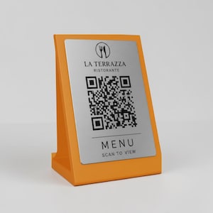 Può includere: Un espositore da tavolo arancione con una placca argentata con un codice QR e il testo "LA TERRAZZA RISTORANTE" e "MENU SCAN TO VIEW". L'espositore è progettato per stare in posizione verticale.