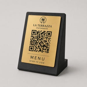Può includere: Un espositore da tavolo nero angolato con una placca color oro. La placca riporta il testo "LA TERRAZZA RISTORANTE", un codice QR e le parole "MENU SCAN TO VIEW". Progettato per l'uso in ristoranti.