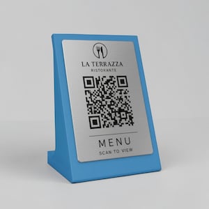 Op de afbeelding: Een blauwe tafelstandaard met een zilveren plaat met een QR-code en de tekst "LA TERRAZZA RISTORANTE" en "MENU SCAN TO VIEW". De standaard is schuin en ontworpen voor gebruik in restaurants.