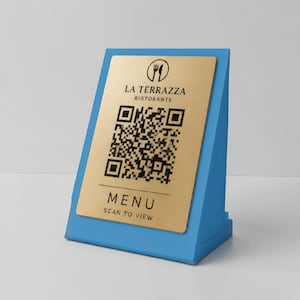 Könnte beinhalten: Ein blauer Tisch-Menühalter mit einer goldfarbenen Platte. Auf der Platte steht der Text "LA TERRAZZA RISTORANTE" und ein QR-Code. Unter dem QR-Code steht das Wort "MENU" und der Text "SCAN TO VIEW".