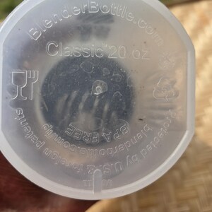K&ouml;nnte beinhalten: Ein klarer BlenderBottle-Deckel mit dem Text "Classic 20 oz." und "BlenderBottle.com" aufgedruckt. Der Deckel ist BPA-frei und durch US-amerikanische und ausl&auml;ndische Patente gesch&uuml;tzt.