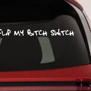 May include: White vinyl decal with the text "DON'T FLIP MY BITCH SWITCH" on a car window. The decal is in a handwritten style. The car is red.